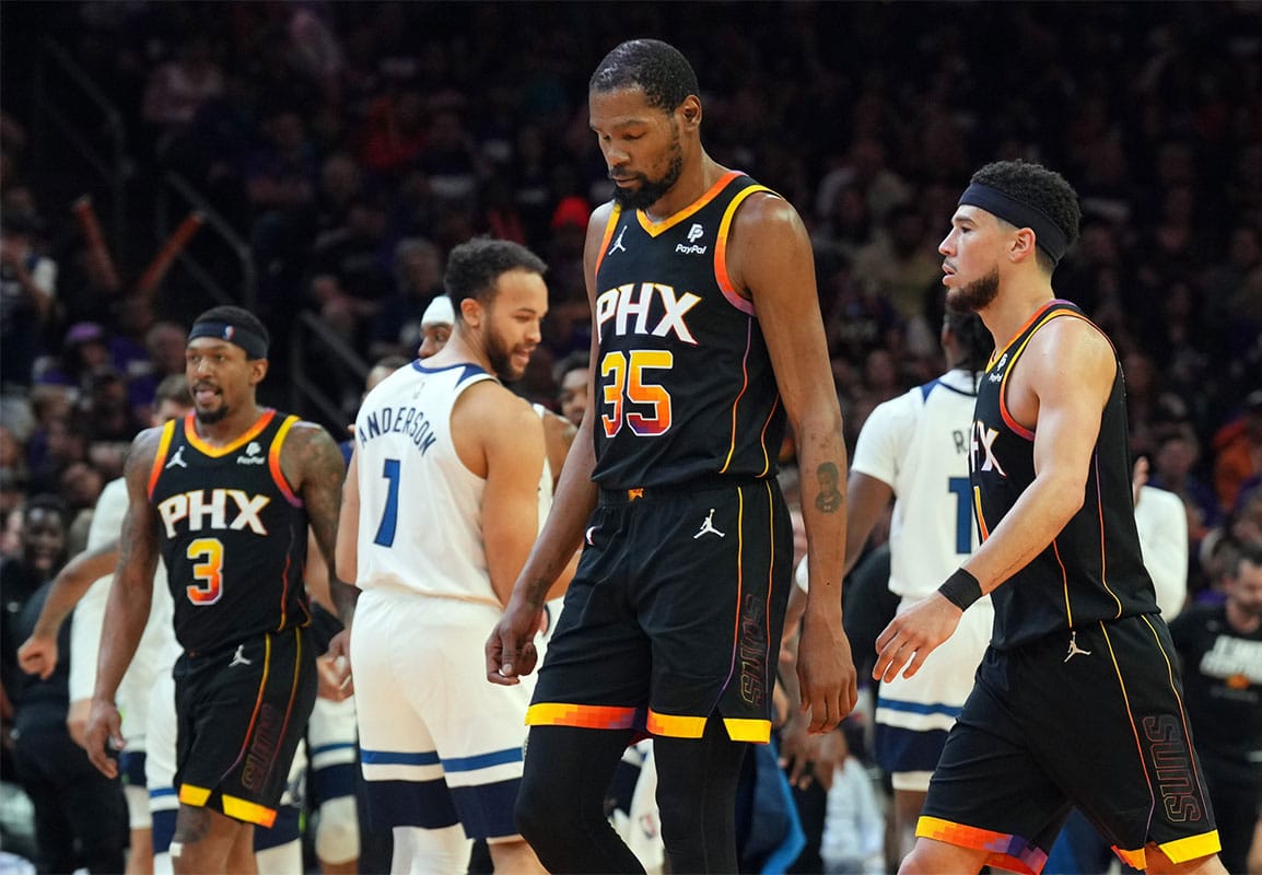 Phoenix Suns guard Bradley Beal (3) and Phoenix Suns forward Kevin Durant (35) and Phoenix Suns guard Devin Booker (1) react while Minnesota Timberwolves celebrate during the second half of game three of the first round for the 2024 NBA playoffs at Footprint Center.