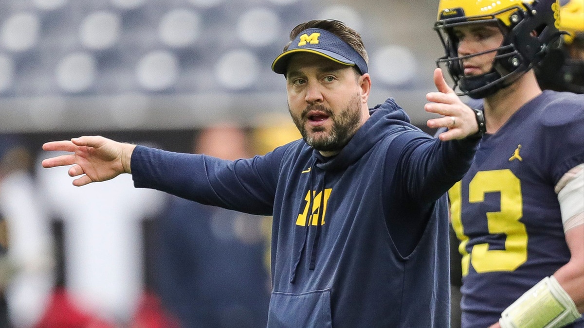 Michigan quarterbacks coach Kirk Campbell talks to players during open practice at NRG Stadium