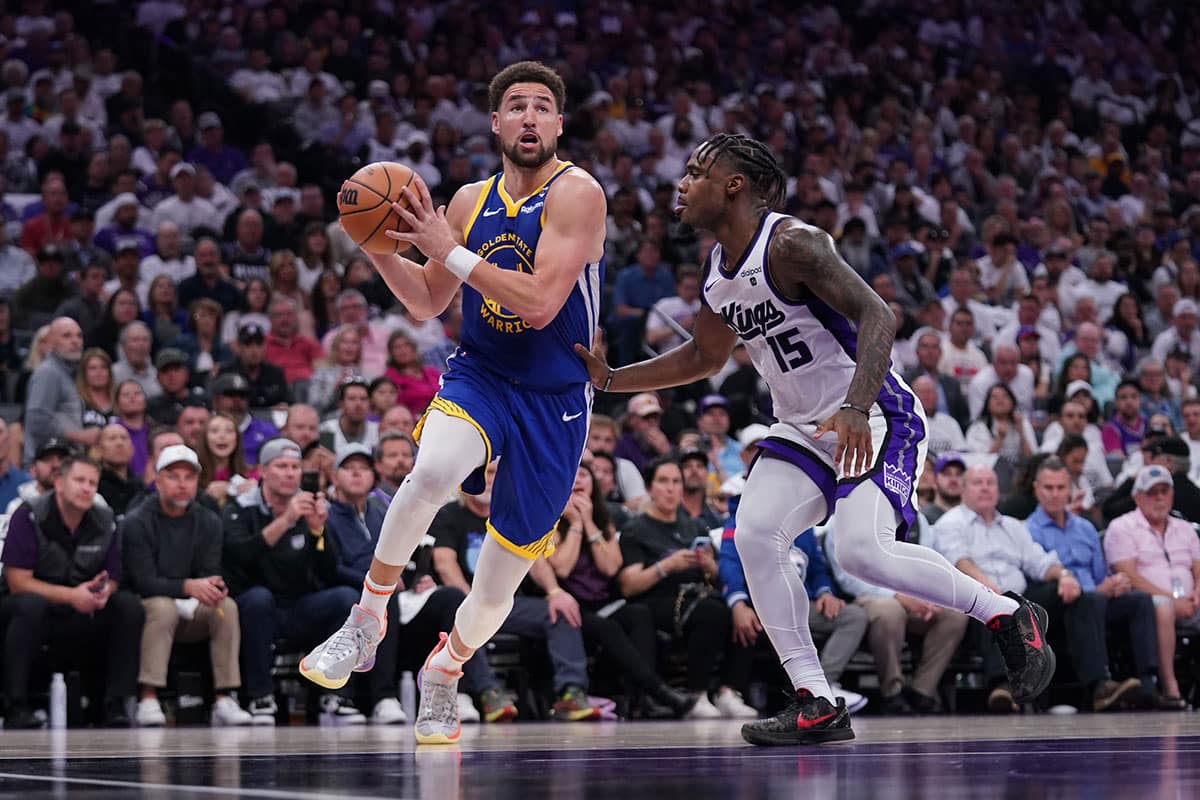 Golden State Warriors guard Klay Thompson (11) drives past Sacramento Kings guard Davion Mitchell (15) in the second quarter during a play-in game of the 2024 NBA playoffs at the Golden 1 Center.