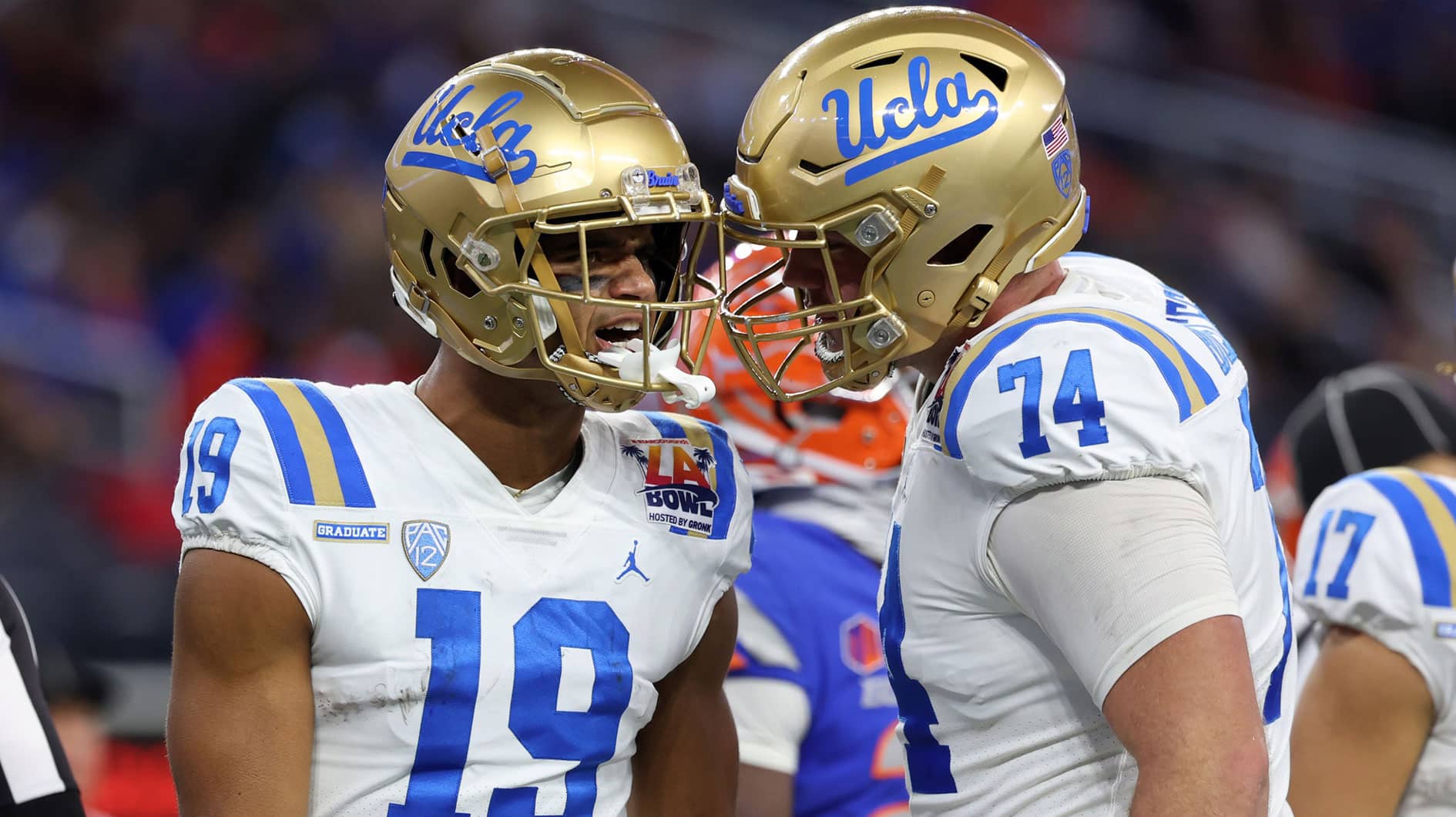 UCLA Bruins wide receiver Kyle Ford (19) celebrates with offensive lineman Spencer Holstege (74) after catching a touchdown pass during the third quarter of the LA Bowl at SoFi Stadium. 