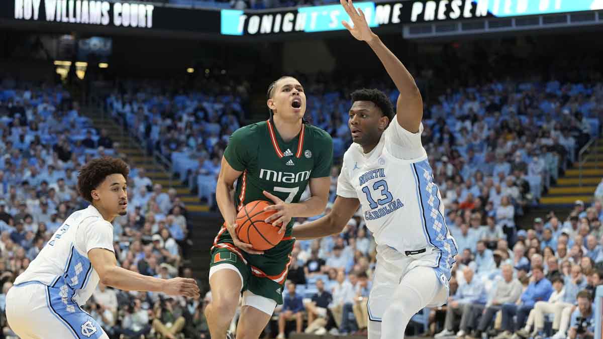 Miami (Fl) Hurricanes guard Kyshawn George (7) with the ball as North Carolina Tar Heels guard Seth Trimble (7) and forward Jalen Washington (13) defend in the first half at Dean E. Smith Center
