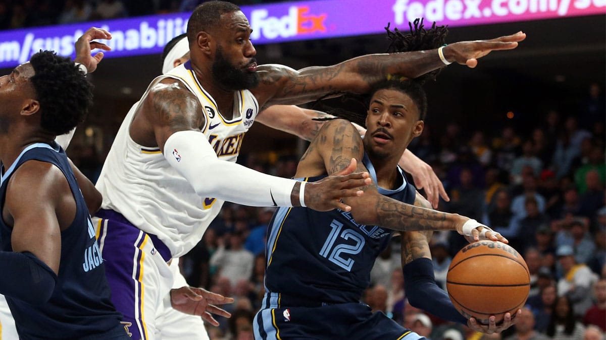 Memphis Grizzlies guard Ja Morant (12) passes the ball as Los Angeles Lakers forward LeBron James (6) defends during the second half during game one of the 2023 NBA playoffs at FedExForum.