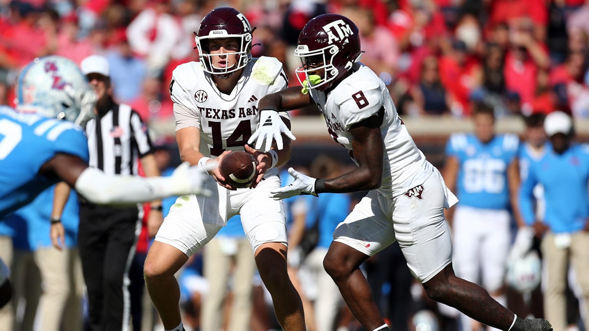  Texas A&M Aggies quarterback Max Johnson (14) hands the ball off to running back Le'Veon Moss (8) during the second half against the Mississippi Rebels at Vaught-Hemingway Stadium.