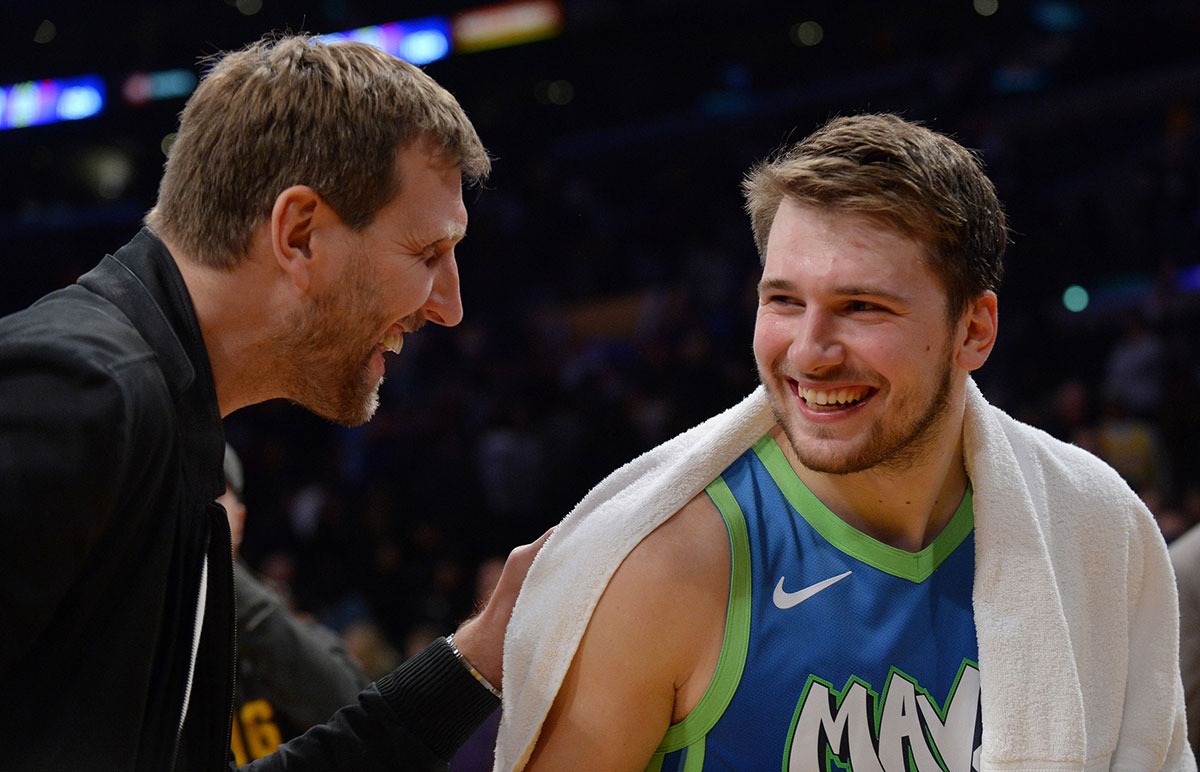 Dallas Mavericks forward Luka Doncic (77) meets with former player Dirk Nowitzki following the 114-100 victory at Staples Center. 