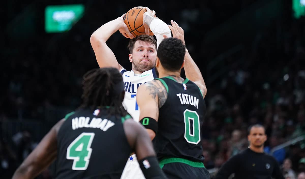 Dallas Mavericks guard Luka Doncic (77) looks to pass the ball against Boston Celtics forward Jayson Tatum (0) in the second quarter at TD Garden.