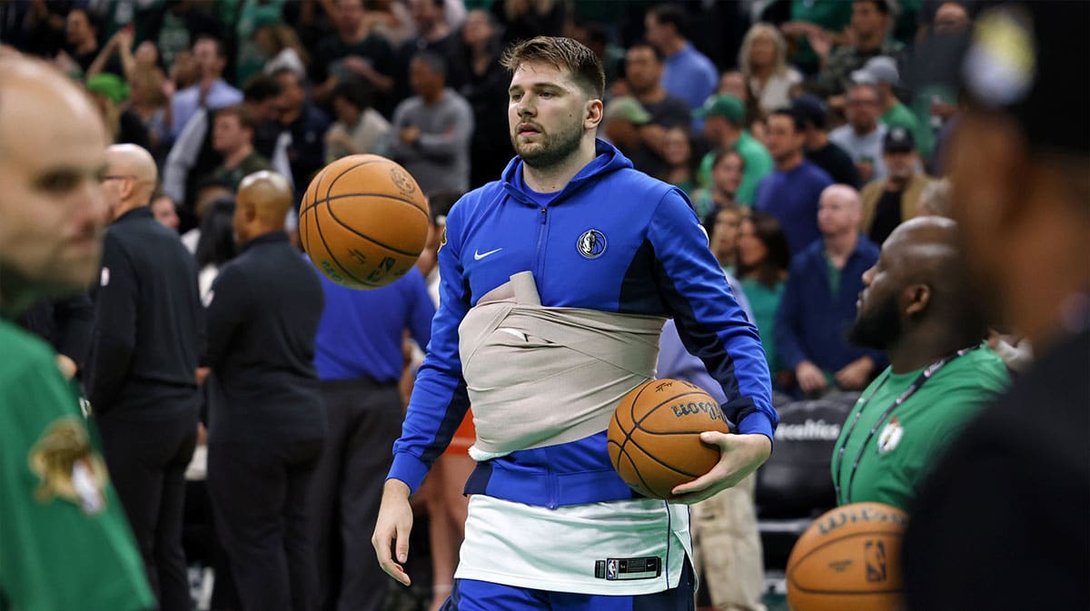Dallas Mavericks guard Luka Doncic (77) wears a wrap around his chest while warming up before game two of the 2024 NBA Finals between the Boston Celtics and the Dallas Mavericks at TD Garden.