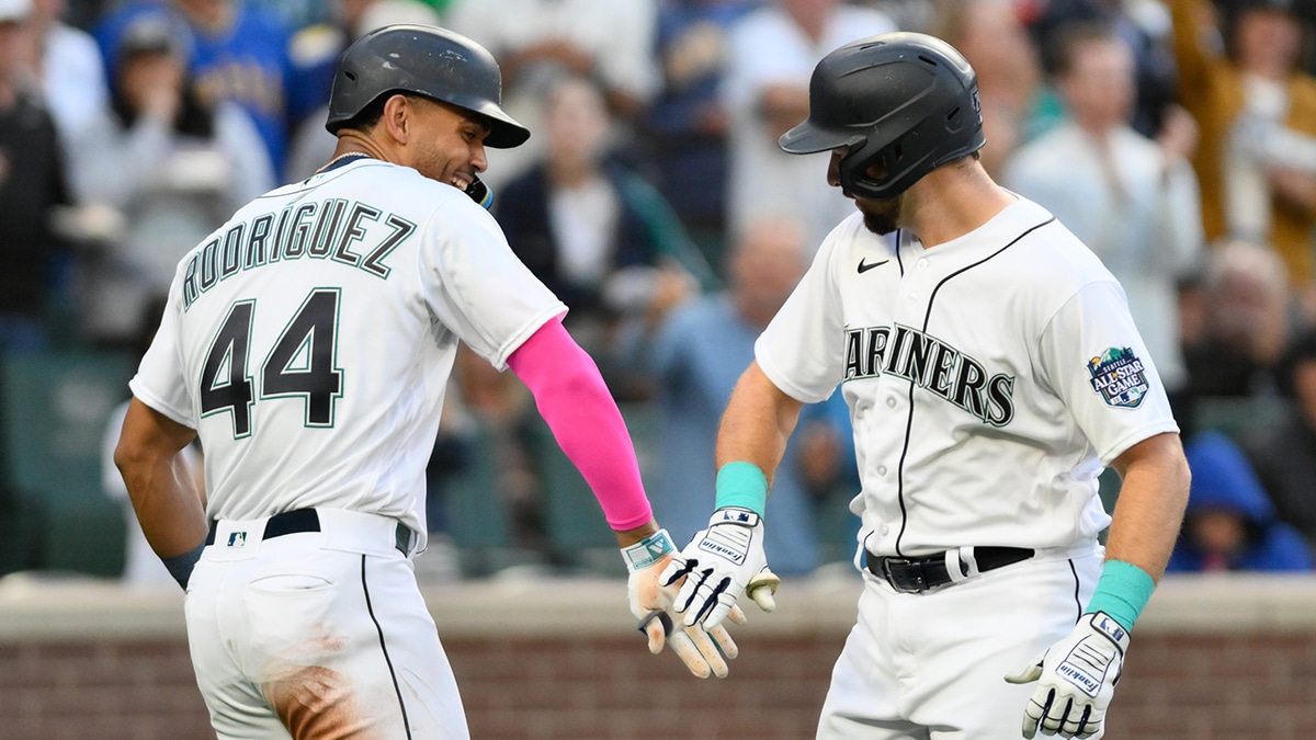Seattle Mariners center fielder Julio Rodriguez (44) and catcher Cal Raleigh (29) celebrate after Raleigh hit a two-run home run against the Los Angeles Angels during the first inning at T-Mobile Park.