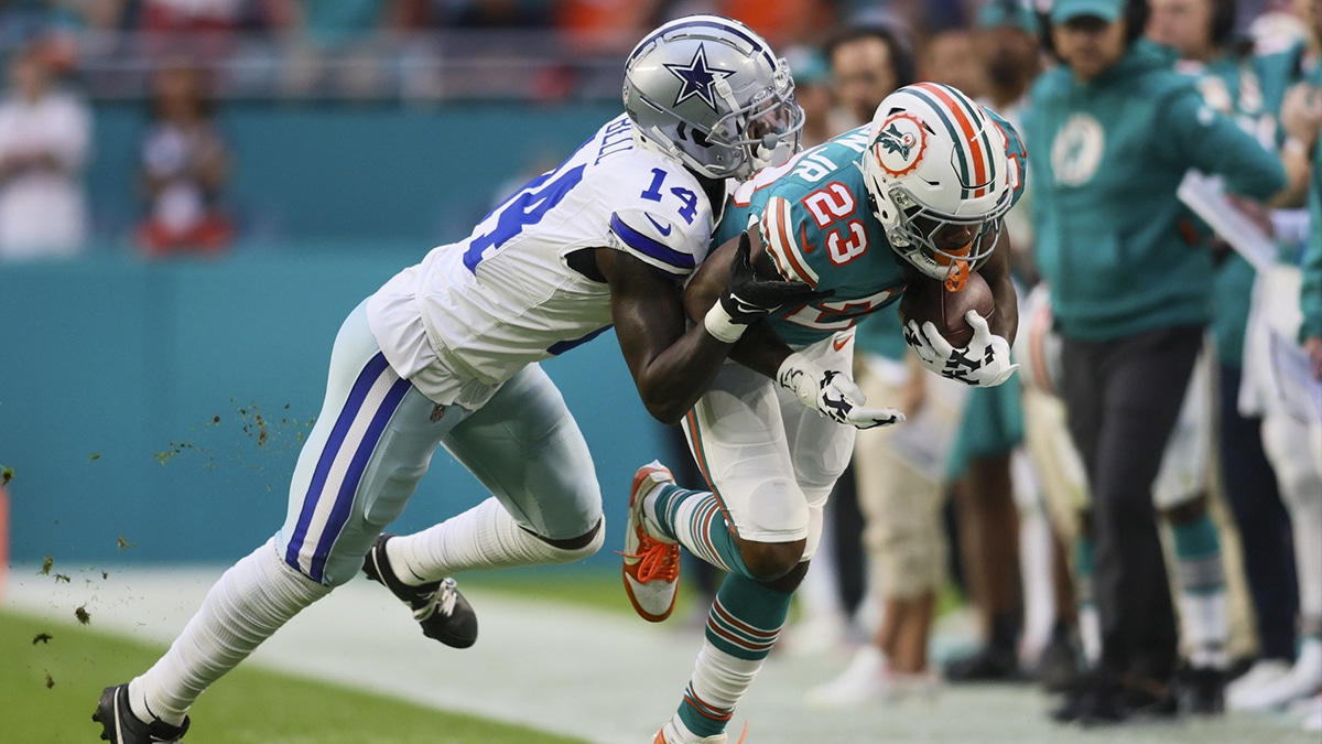 Dec 24, 2023; Miami Gardens, Florida, USA; Miami Dolphins running back Jeff Wilson Jr. (23) runs with the football as Dallas Cowboys safety Markquese Bell (14) pushes him out of bounds during the first quarter at Hard Rock Stadium