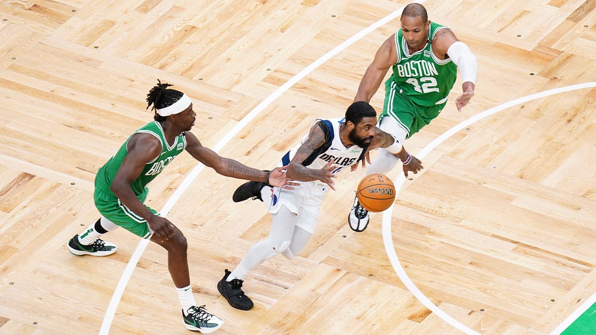 Dallas Mavericks guard Kyrie Irving (11) controls the ball against Boston Celtics guard Jrue Holiday (4) and center Al Horford (42) in the second quarter during game five of the 2024 NBA Finals at TD Garden
