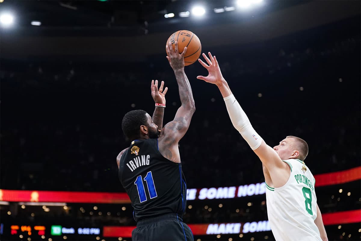 Dallas Mavericks guard Kyrie Irving (11) shoots against Boston Celtics center Kristaps Porzingis (8) in the first quarter during game one of the 2024 NBA Finals at TD Garden. 
