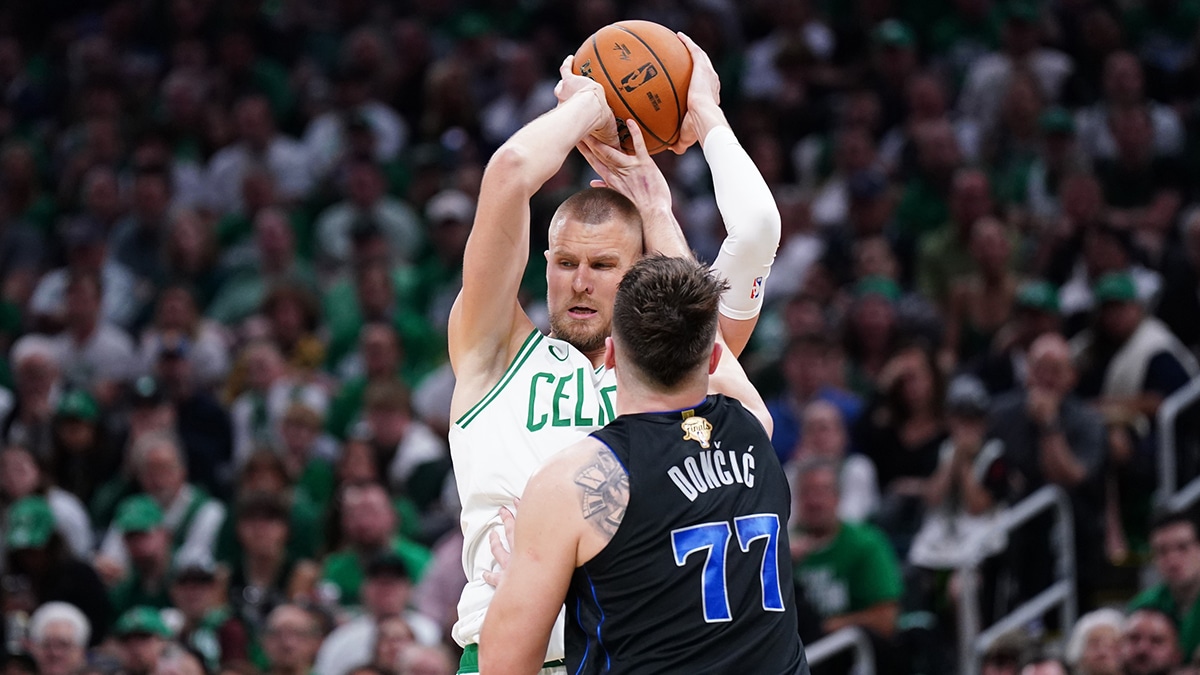 Boston Celtics center Kristaps Porzingis (8) controls the ball against Dallas Mavericks guard Luka Doncic (77) in the third quarter during game one of the 2024 NBA Finals at TD Garden.
