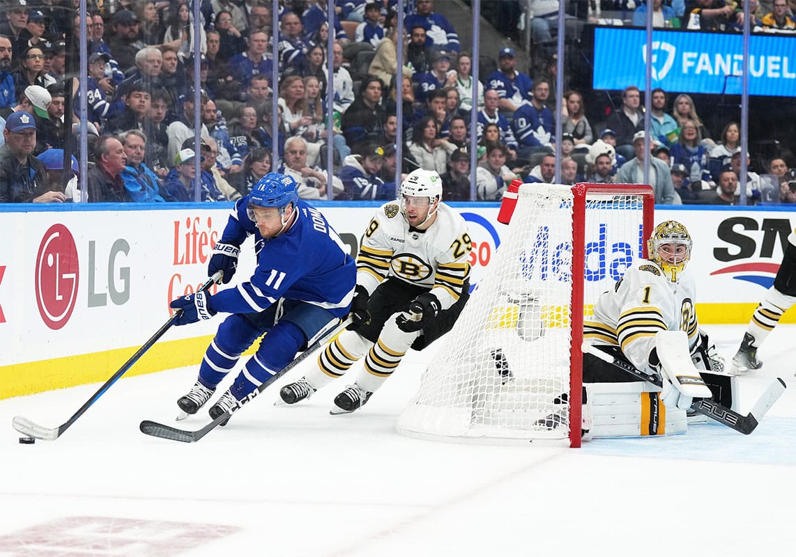 Toronto Maple Leafs center Max Domi (11) battles for the puck with Boston Bruins defenseman Parker Wotherspoon (29) behind goaltender Jeremy Swayman (1) during the third period in game four of the first round of the 2024 Stanley Cup Playoffs at Scotiabank Arena. 
