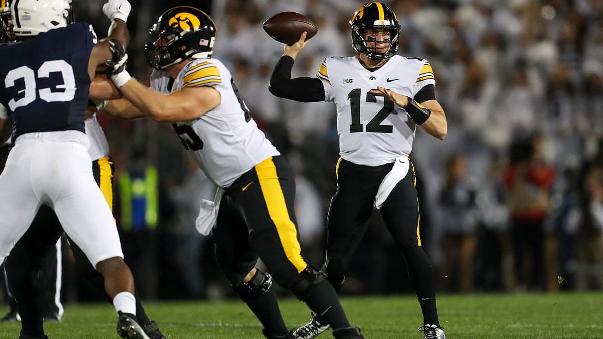  Iowa Hawkeyes quarterback Cade McNamara (12) looks to throw a pass during the first quarter against the Penn State Nittany Lions at Beaver Stadium.
