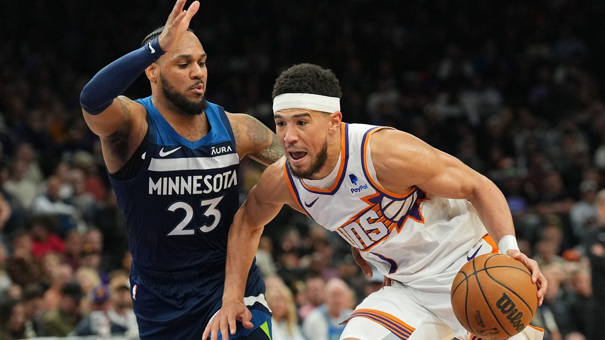 Phoenix Suns guard Devin Booker (1) drives against Minnesota Timberwolves guard Monte Morris (23) during the second half at Footprint Center.
