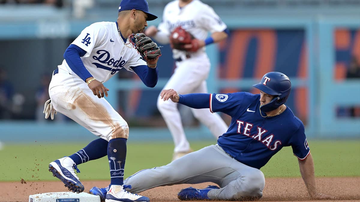 Texas Rangers third baseman Josh Smith (8) beats the tag by Los Angeles Dodgers shortstop Mookie Betts (50) for a stolen base in the first inning at Dodger Stadium.