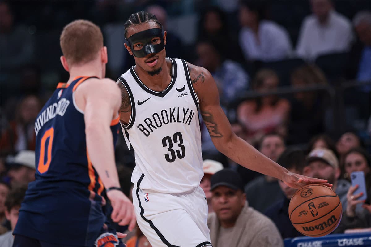 Brooklyn Nets center Nic Claxton (33) dribbles against New York Knicks guard Donte DiVincenzo (0) during the first quarter at Madison Square Garden.