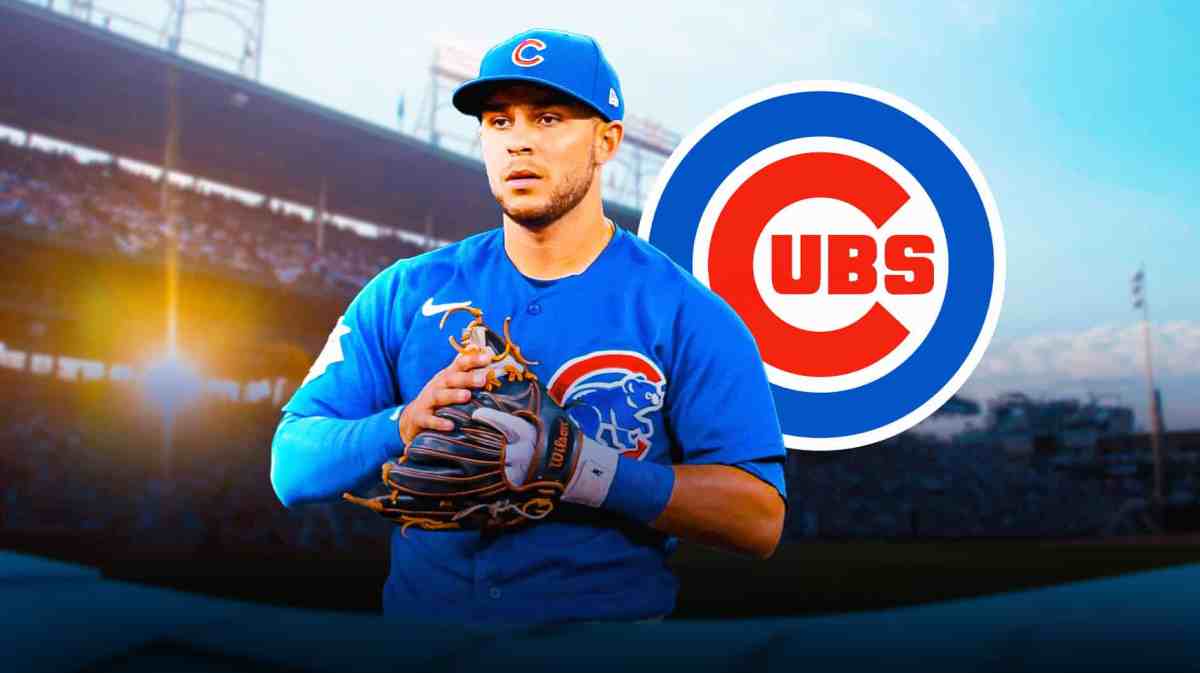 Nick Madrigal holding his left hand in pain. Cubs logo in the background.