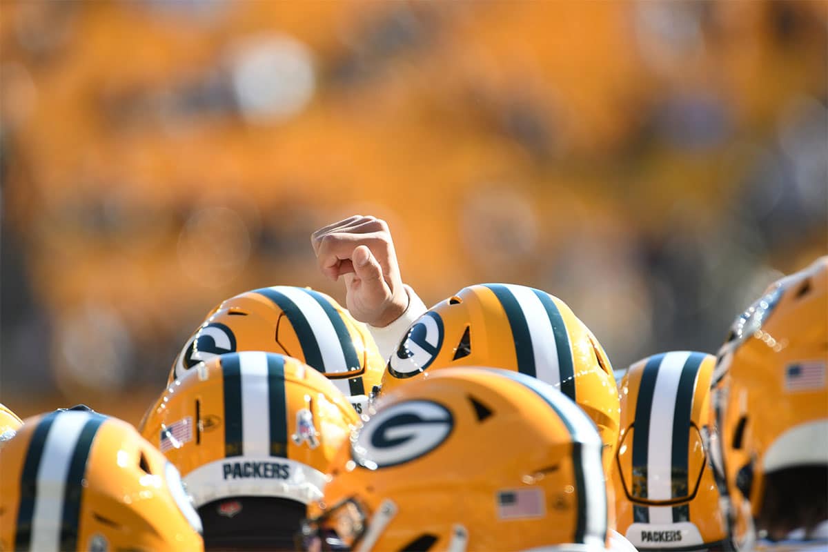 Green Bay Packers quarterback Jordan Love raises his fist in a huddle before playing the Pittsburgh Steelers at Acrisure Stadium. 