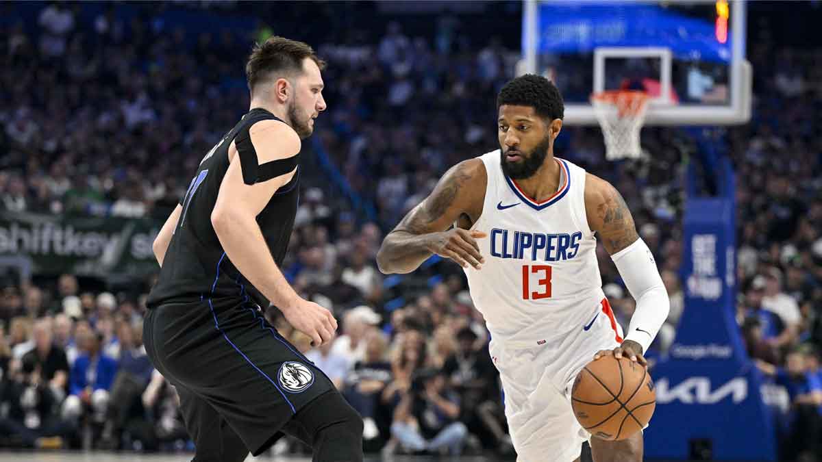 LA Clippers forward Paul George (13) moves the ball past Dallas Mavericks guard Luka Doncic (77) during the first quarter during game six of the first round for the 2024 NBA playoffs at American Airlines Center.
