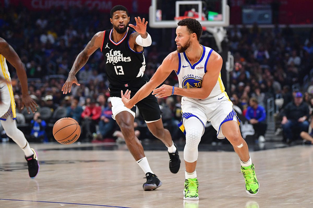 Warriors guard Stephen Curry (30) moves the ball ahead of Los Angeles Clippers forward Paul George (13)
