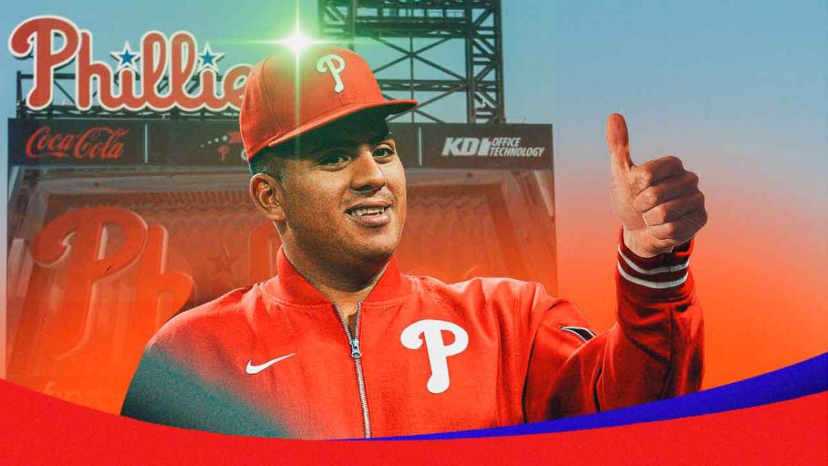 Ranger Suarez with a thumbs up using his left hand and a green light over his head. Phillies logo in the background.