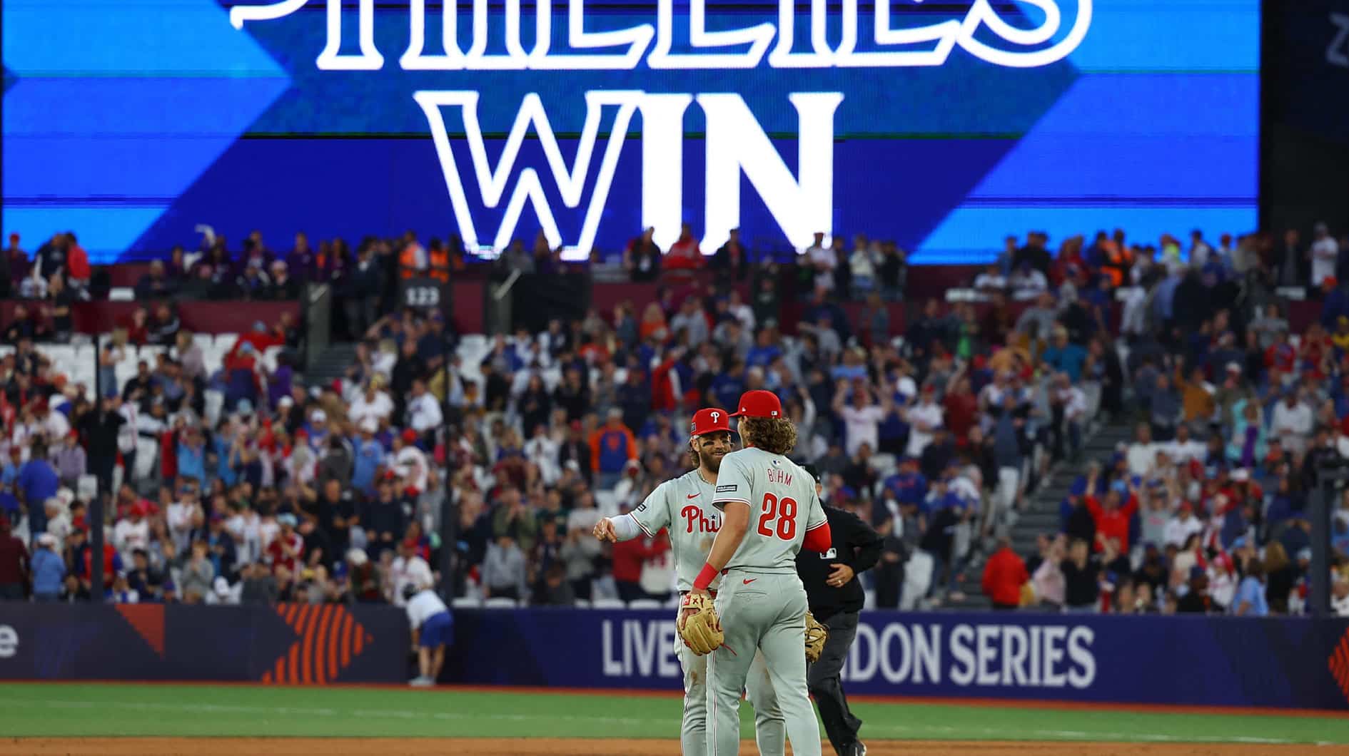 Philadelphia Phillies players Bryce Harper and Alec Bohm celebrate after defeating the New York Mets during a London Series baseball game at Queen Elizabeth Olympic Park.