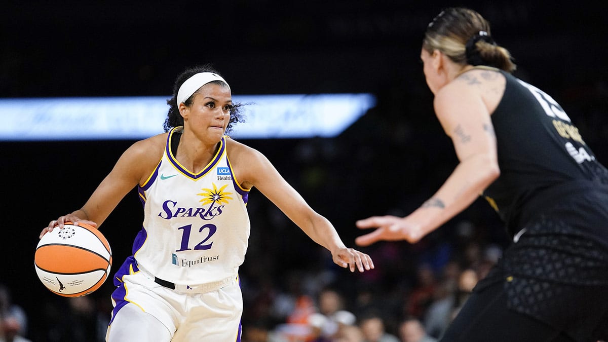 Los Angeles Sparks guard/forward Rae Burrell (12) dribbles the ball against Las Vegas Aces center/forward Cayla George (13) during the fourth quarter at Michelob Ultra Arena.