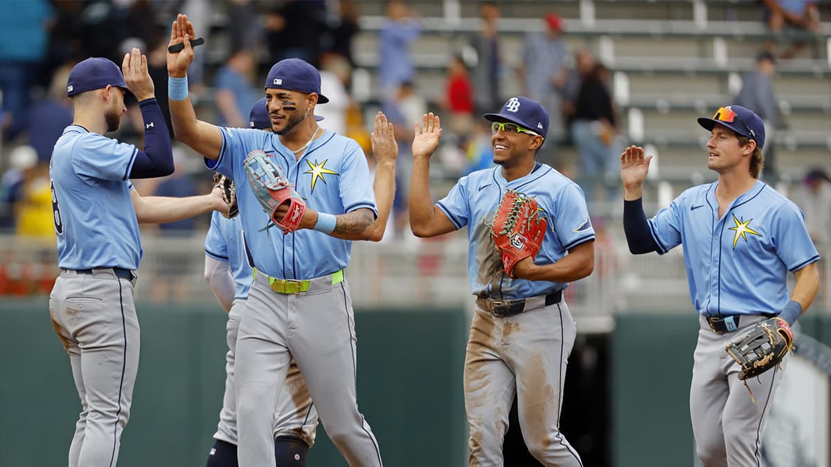 Tampa Bay Rays center fielder Jose Siri (22) and left fielder Richard Palacios (1) and right fielder Jonny DeLuca (21) celebrate the win over the Minnesota Twins after ten innings at Target Field.