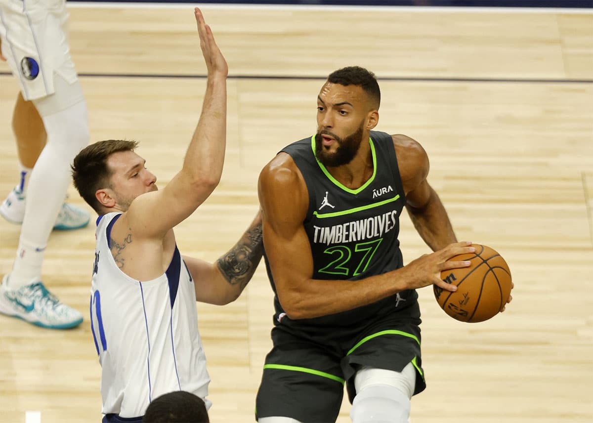 Minnesota Timberwolves center Rudy Gobert (27) looks to pass against Dallas Mavericks guard Luka Doncic (77) during the first quarter in game five of the western conference finals for the 2024 NBA playoffs at Target Center.