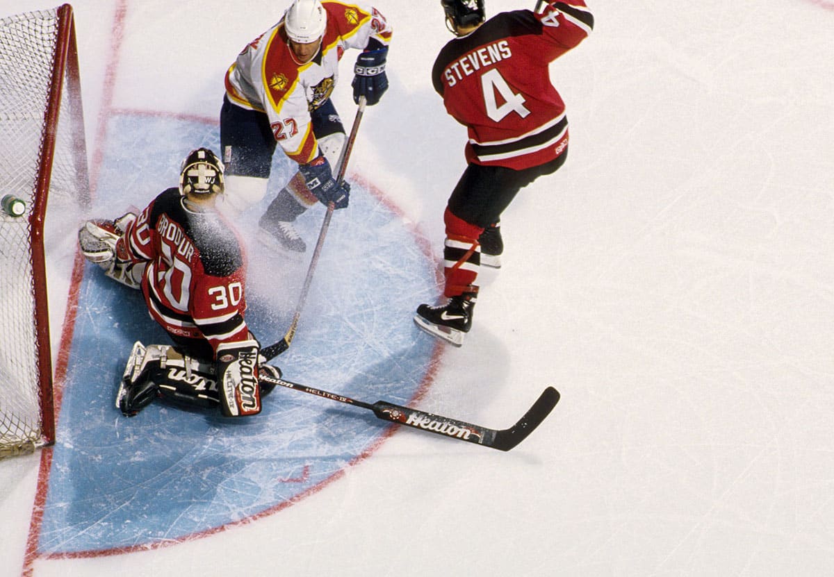  New Jersey Devils goalie Martin Brodeur (30) in action with defender Scott Stevens (4) against Florida Panthers forward Scott Mellanby (27) during the 1996-97 season at Miami Arena.