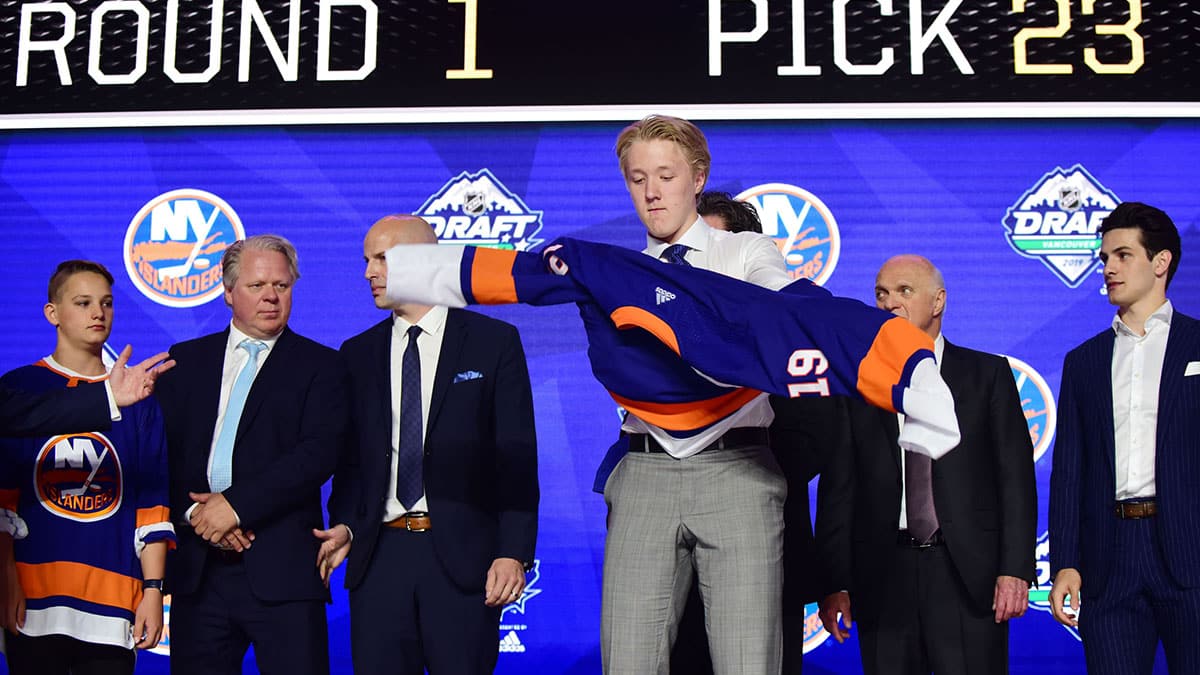 Simon Holmstrom puts on a jersey after being selected as the number twenty-three overall pick to the New York Islanders in the first round of the 2019 NHL Draft at Rogers Arena.