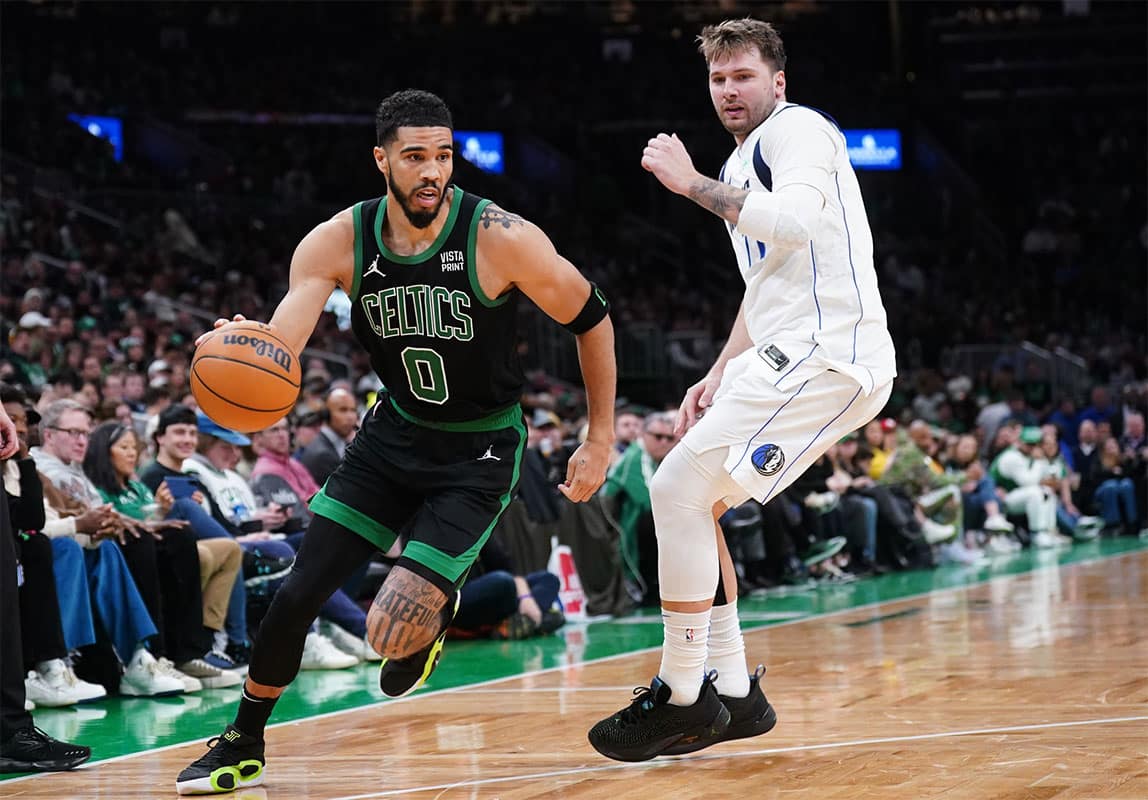 Boston Celtics forward Jayson Tatum (0) drives the ball against Dallas Mavericks guard Luka Doncic (77) in the second half at TD Garden.
