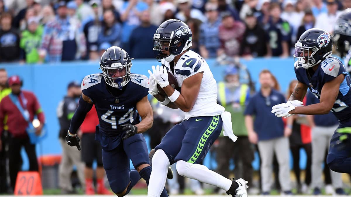 Seattle Seahawks wide receiver Jaxon Smith-Njigba (11) catches a pass for a first down before being tackled by Tennessee Titans safety Mike Brown (44) during the second half at Nissan Stadium.