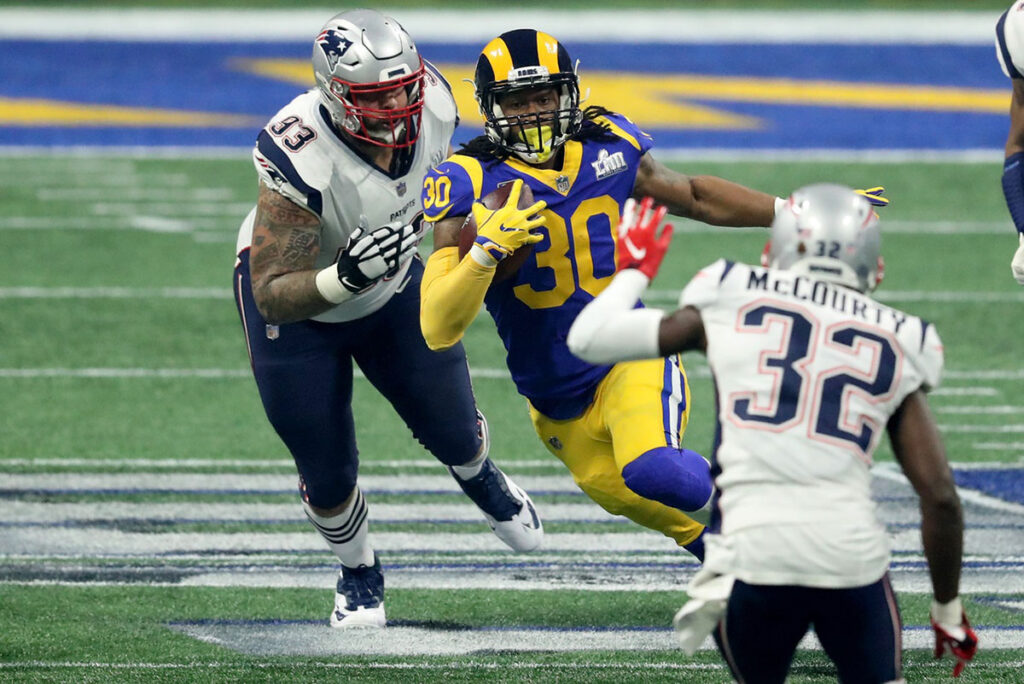 Los Angeles Rams running back Todd Gurley (30) runs the ball against New England Patriots defensive tackle Lawrence Guy (93) and free safety Devin McCourty (32) during the third quarter of Super Bowl LIII at Mercedes-Benz Stadium. M