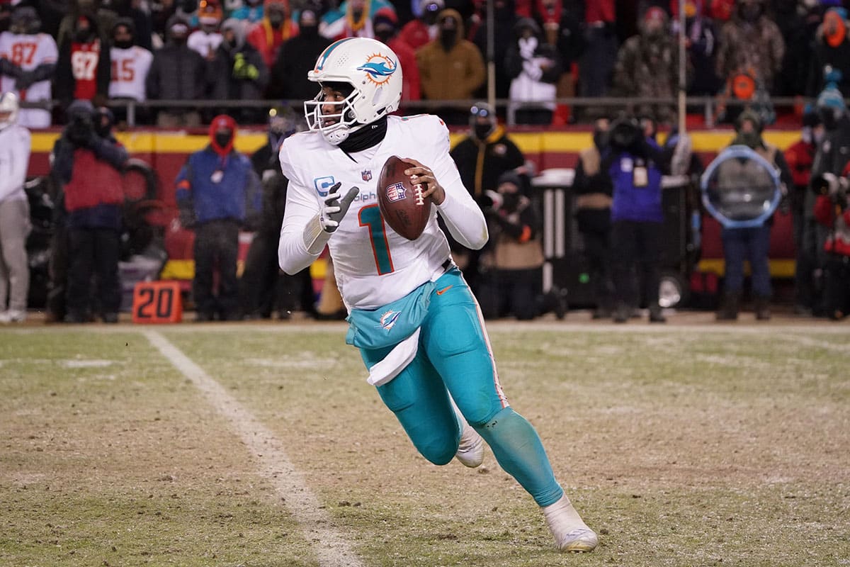 Miami Dolphins quarterback Tua Tagovailoa (1) moves out to pass against the Kansas City Chiefs during the second half of the 2024 AFC wild card game at GEHA Field at Arrowhead Stadium.