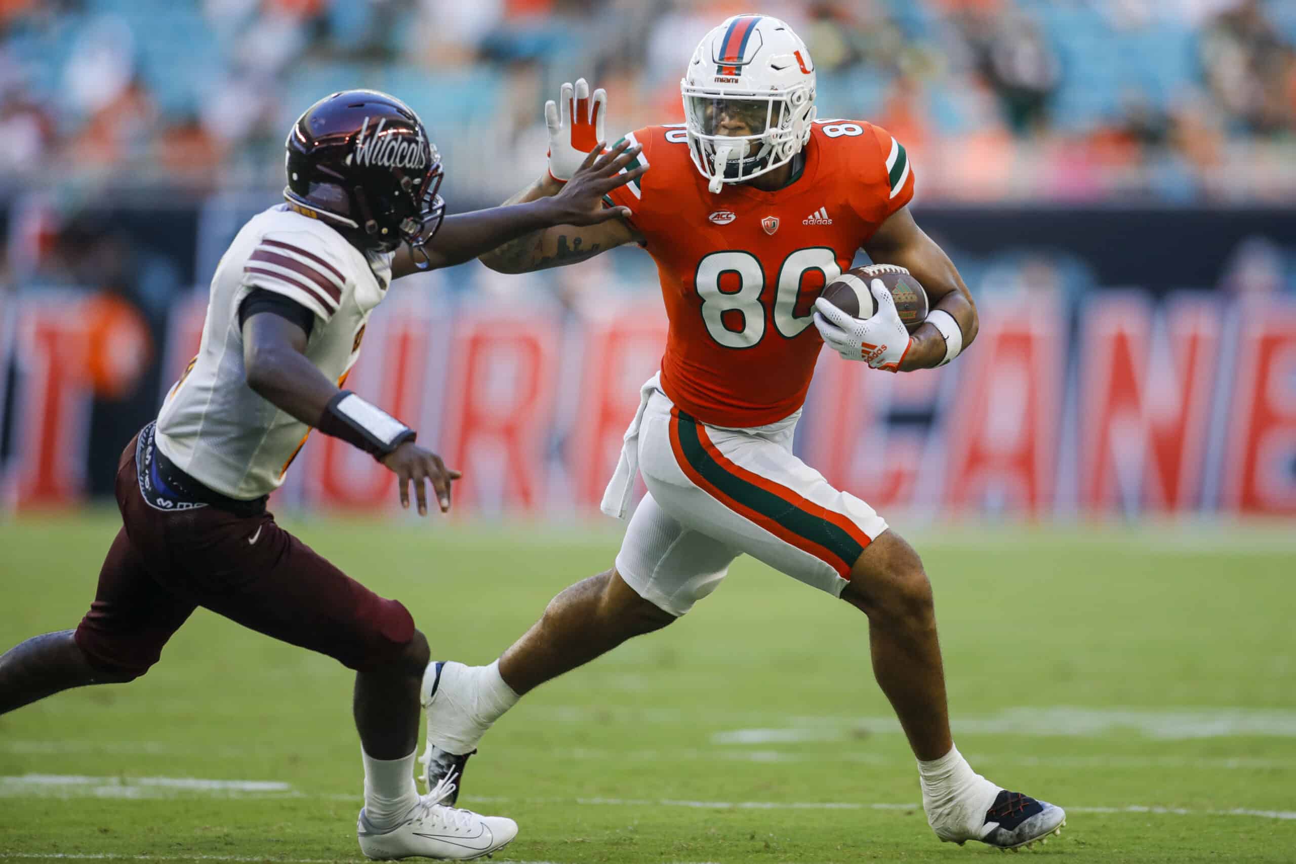 Sep 3, 2022; Miami Gardens, Florida, USA; Miami Hurricanes tight end Elijah Arroyo (80) runs with the football and protects it from Bethune Cookman Wildcats safety Jaquan Jackson (5) during the third quarter at Hard Rock Stadium. 