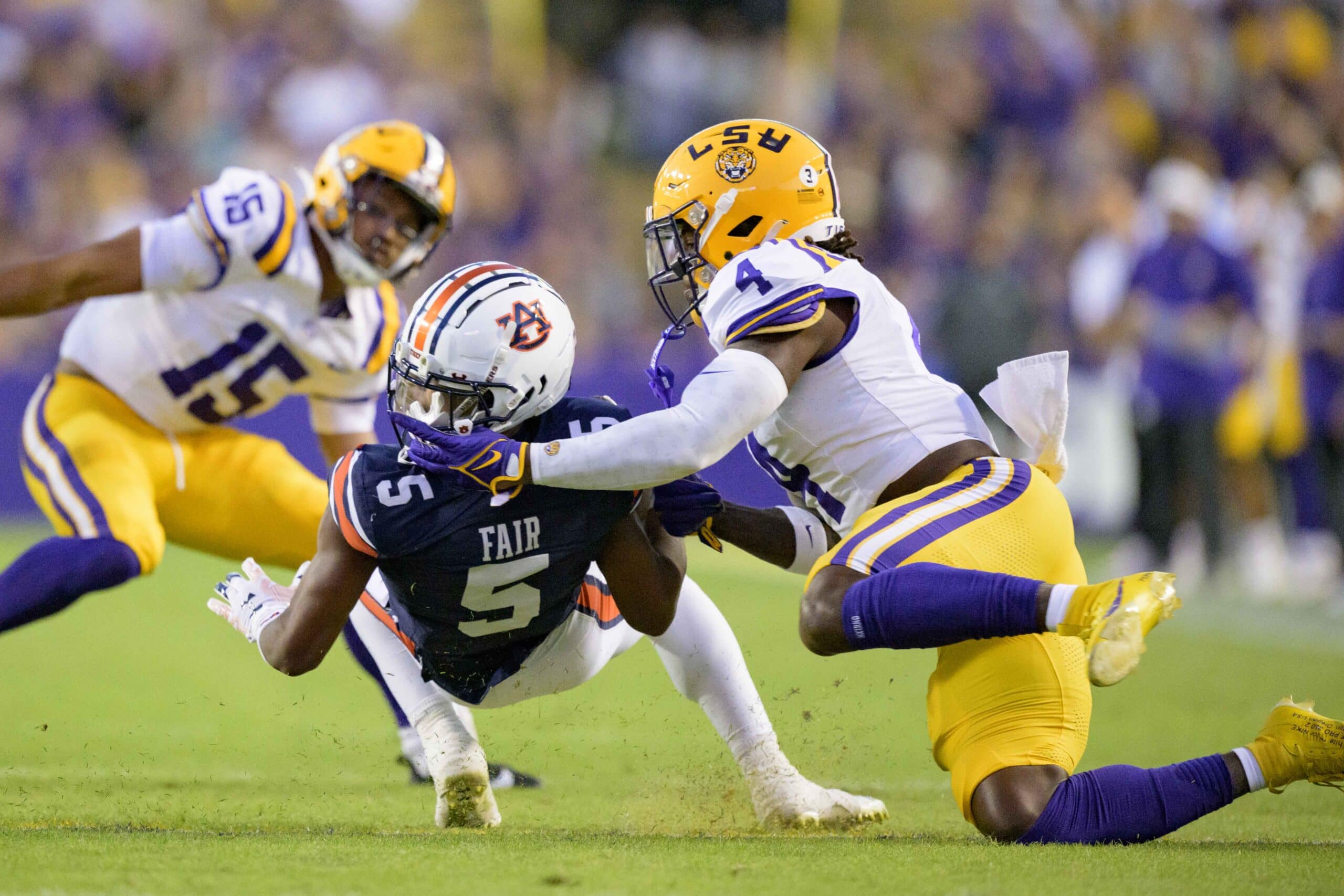 Oct 14, 2023; Baton Rouge, Louisiana, USA; LSU Tigers linebacker Harold Perkins Jr. (4) gets his fingers caught in the helmet of Auburn Tigers wide receiver Jay Fair (5) but there was no flag during the first quarter at Tiger Stadium. 