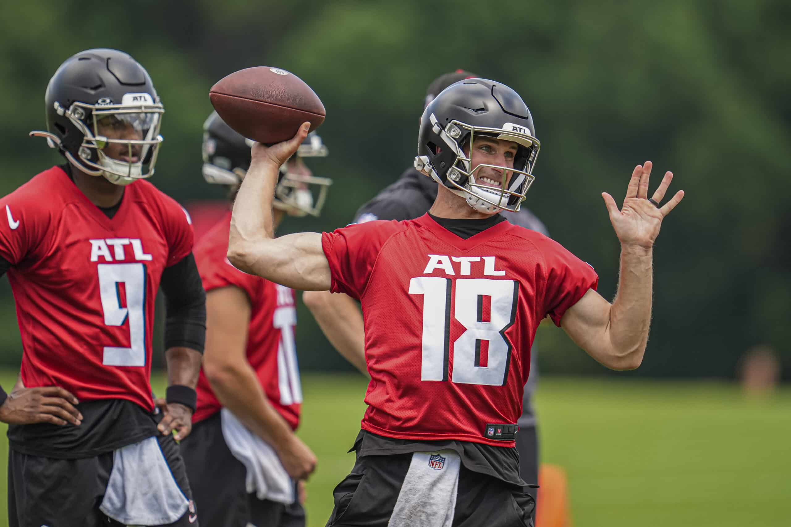 Jun 3, 2024; Atlanta, GA, USA; Atlanta Falcons quarterback Kirk Cousins (18) throws while quarterback Michael Penix Jr (9) watches on the field during Falcons OTA at the Falcons Training facility. 
