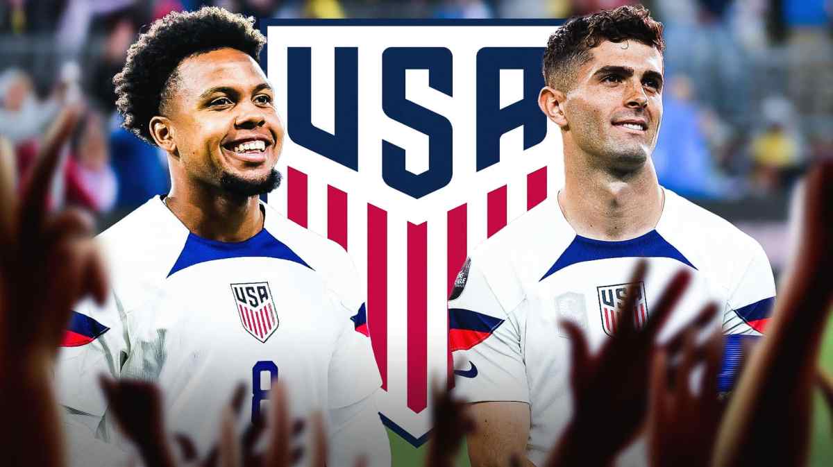 Weston McKennie and Christian Pulisic laughing in front of the USMNT logo