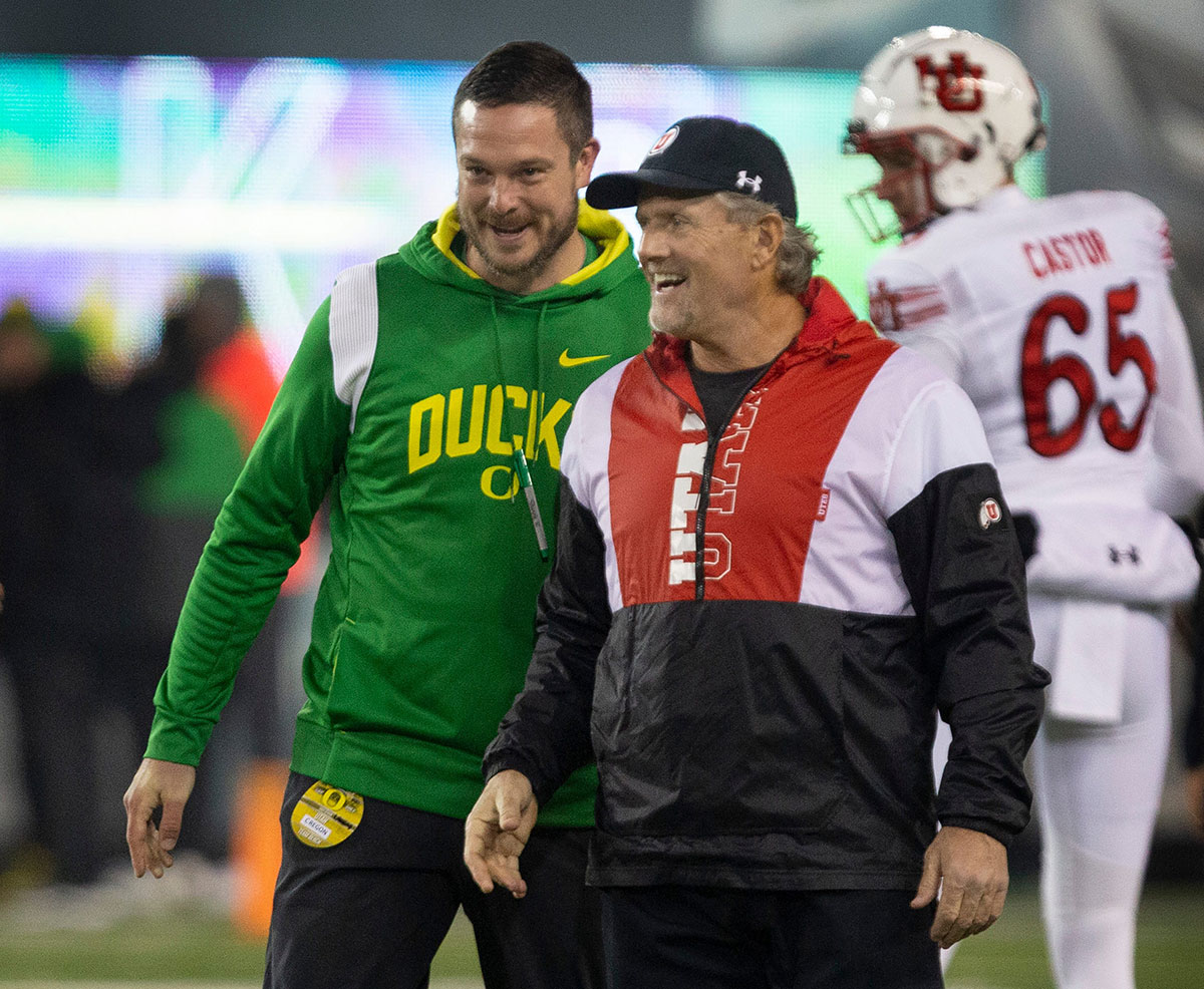 Oregon coach Dan Lanning, left, and Utah coach Kyle Whittingham meet at midfield before the game at Autzen Stadium.