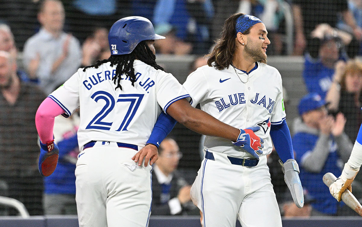 Toronto Blue Jays first baseman Vladimir Guerrero Jr. (27) and shortstop Bo Bichette (11) celebrate after scoring against the Seattle Mariners in the third inning at Rogers Centre.