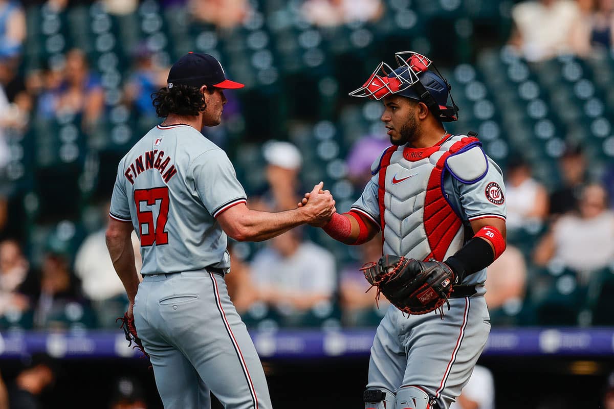 Washington Nationals relief pitcher Kyle Finnegan (67) reacts with catcher Keibert Ruiz (20) after the game against the Colorado Rockies at Coors Field. 