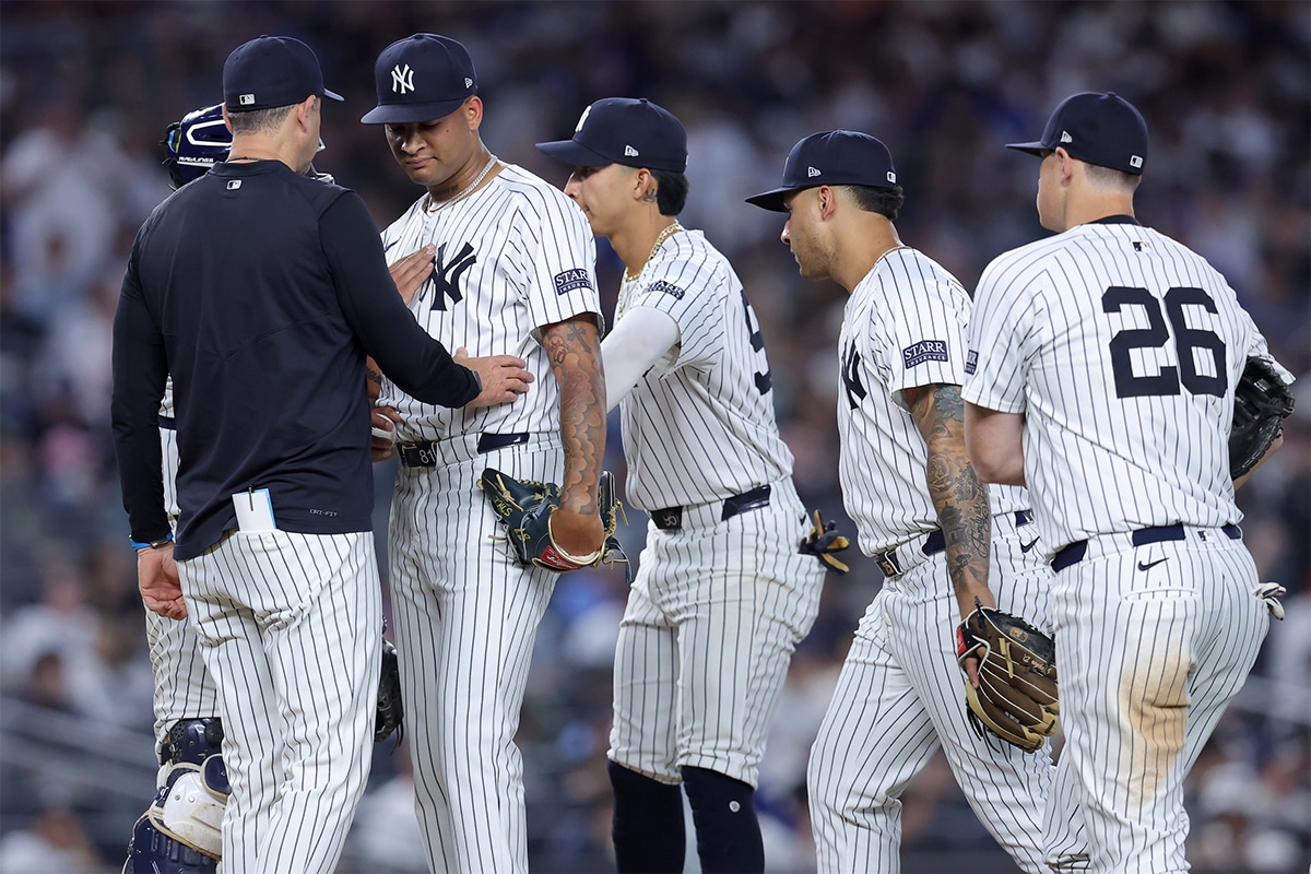 New York Yankees manager Aaron Boone (17) talks to starting pitcher Luis Gil (81) before taking him out of the game against the Los Angeles Dodgers during the sixth inning at Yankee Stadium. 