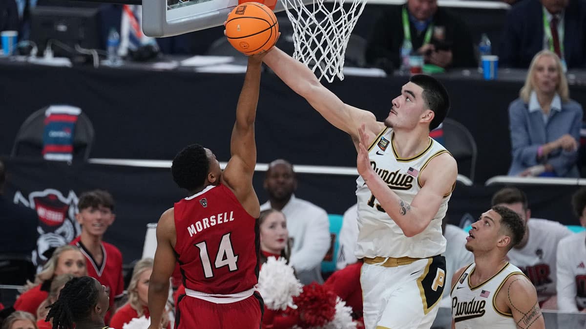 Purdue Boilermakers center Zach Edey (15) blocks a shot by North Carolina State Wolfpack guard Casey Morsell (14) in the semifinals of the men's Final Four of the 2024 NCAA Tournament at State Farm Stadium.