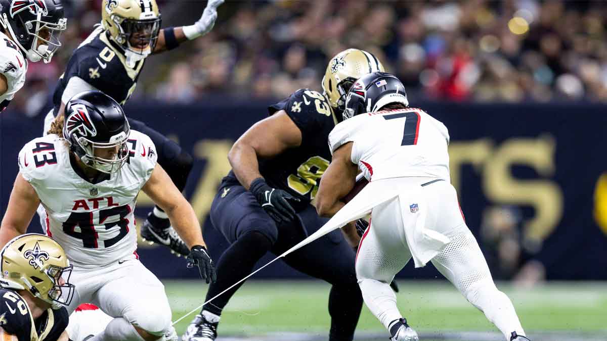 Jan 7, 2024; New Orleans, Louisiana, USA; New Orleans Saints linebacker Pete Werner (20) shreds the jersey of Atlanta Falcons running back Bijan Robinson (7) on a run during the first half at Caesars Superdome. Mandatory Credit: Stephen Lew-USA TODAY Sports