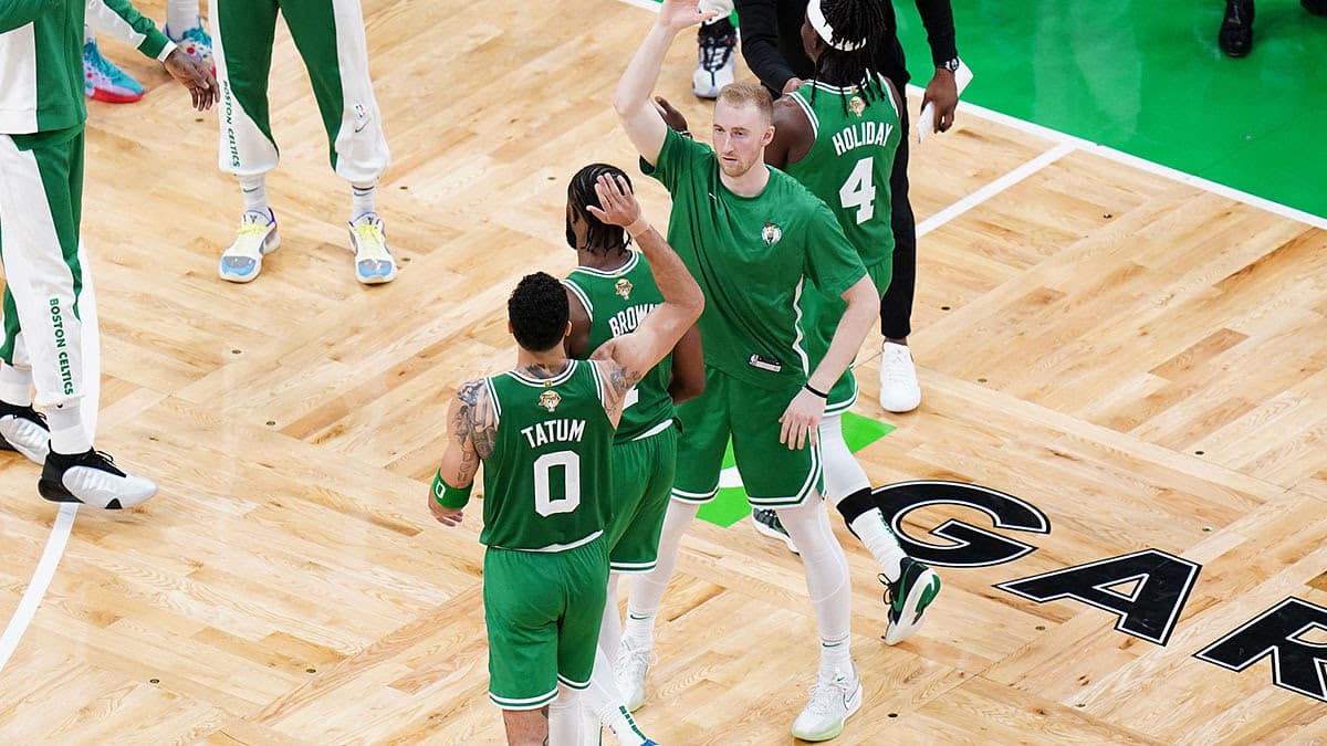 Boston Celtics forward Sam Hauser (30) reacts with guard Jaylen Brown (7) and forward Jayson Tatum (0) in the third quarter against the Dallas Mavericks during game five of the 2024 NBA Finals at TD Garden.