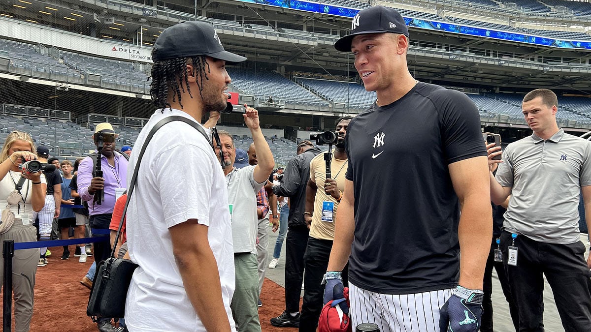 New York Yankees center fielder Aaron Judge (99) talks to New York Knicks guard Jalen Brunson before a game against the New York Mets at Yankee Stadium.