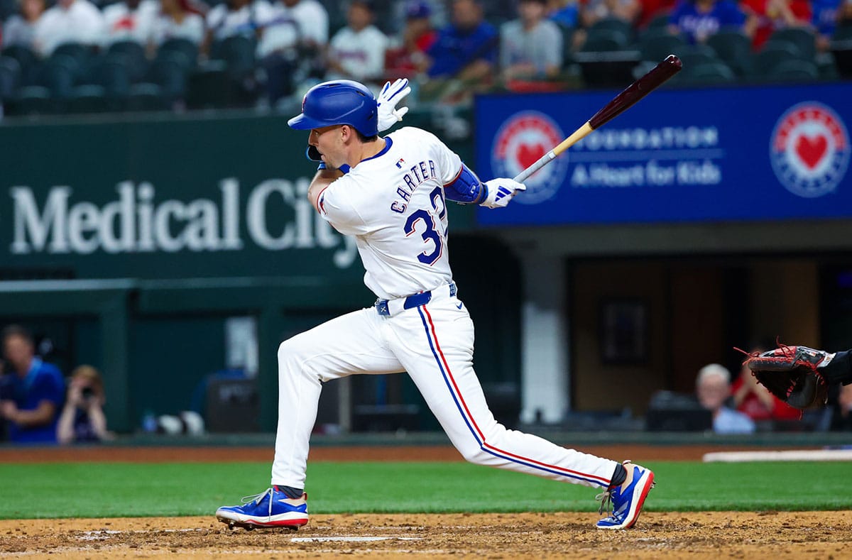 Texas Rangers outfielder Evan Carter (32) hits an rbi single during the eighth inning against the Washington Nationals at Globe Life Field.