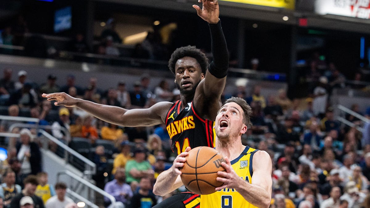 Apr 14, 2024; Indianapolis, Indiana, USA; Indiana Pacers guard T.J. McConnell (9) shoots the ball while Atlanta Hawks forward AJ Griffin (14) defends in the first half at Gainbridge Fieldhouse.