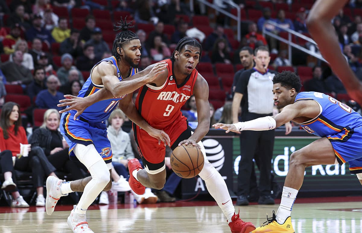 Houston Rockets guard Josh Christopher (9) drives with the ball as Oklahoma City Thunder guard Isaiah Joe (11) and guard Aaron Wiggins (21) defend during the second quarter at Toyota Center.